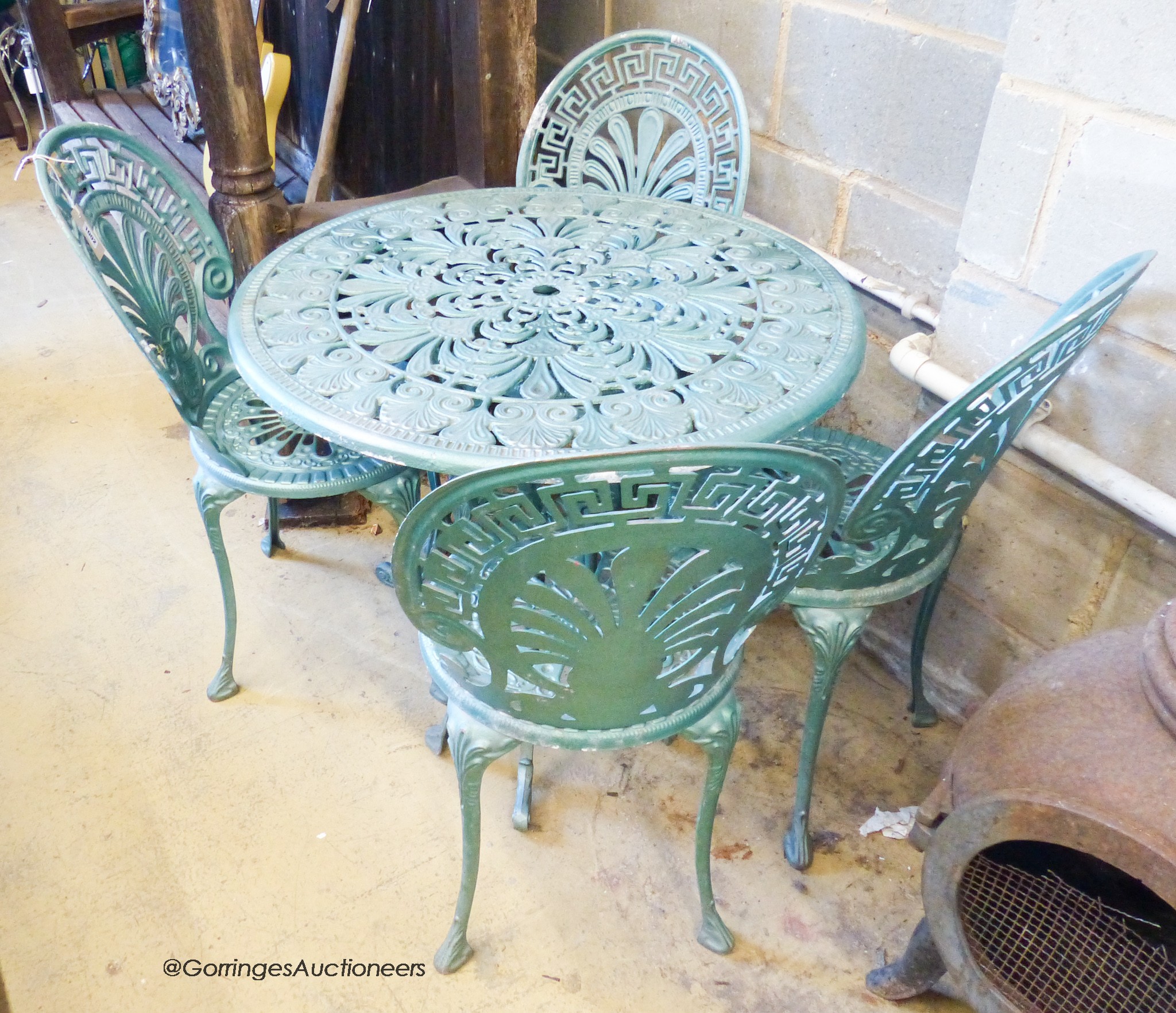 A Victorian style circular aluminium garden table, diameter 80cm, together with four matching garden chairs